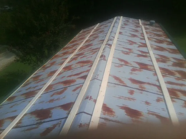 Rusted metal roof panels with new wood purlins before replacement — Storm Damage Roof Repair in Bergheim by Roofing Brothers