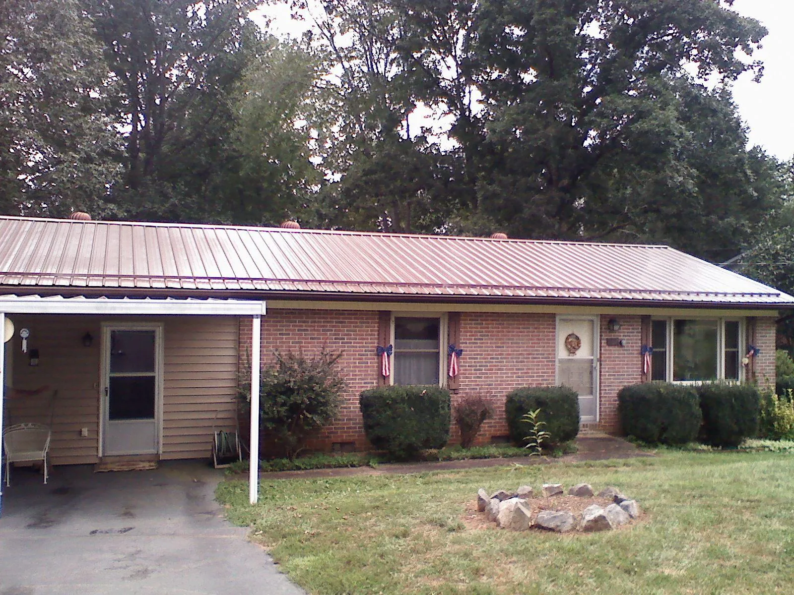 Bronze metal roof and carport on a brick ranch home — Roof Repair work by our crew in Bergheim